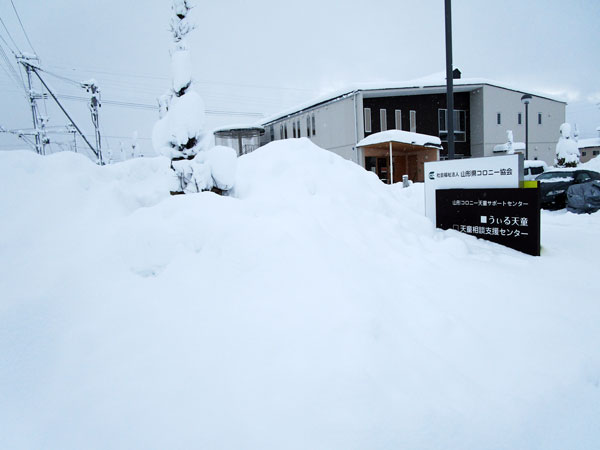 雪壁に覆われた天童サポートセンターの写真です。